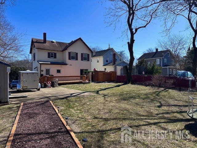 view of yard featuring a residential view, fence, and a deck