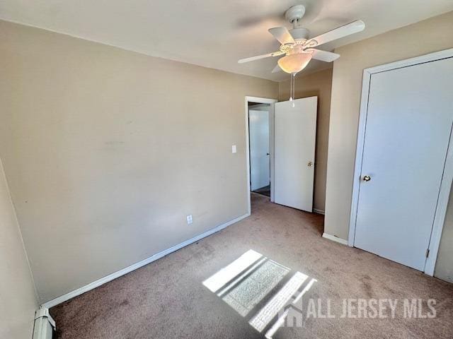 unfurnished bedroom with baseboards, carpet, and a ceiling fan