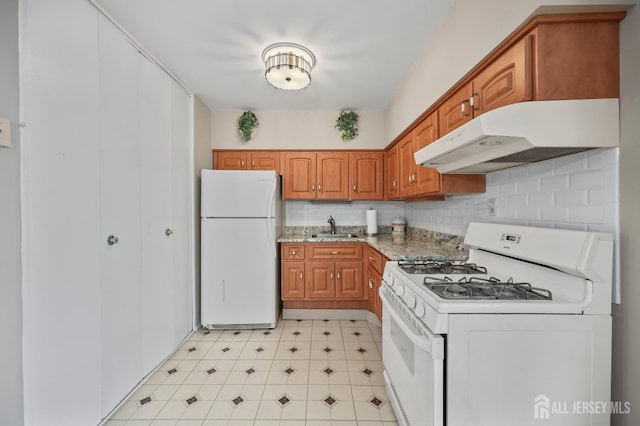 10 Nebraska Dr, Old Bridge, NJ 07747 - kitchen featuring white appliances, under cabinet range hood, a sink, brown cabinets, and backsplash