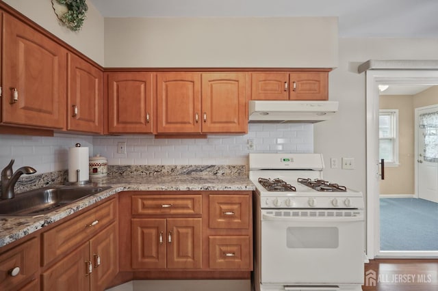 10 Nebraska Dr, Old Bridge, NJ 07747 - kitchen featuring white gas stove, under cabinet range hood, a sink, and decorative backsplash