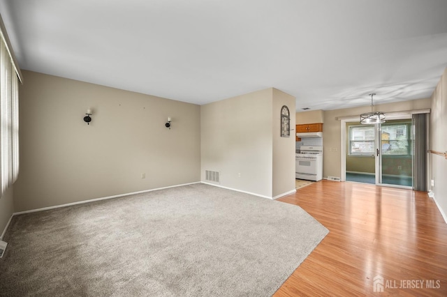 10 Nebraska Dr, Old Bridge, NJ 07747 - unfurnished living room featuring baseboards, light wood finished floors, and a chandelier