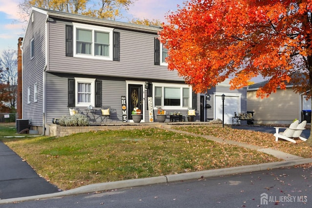 view of front of house featuring central AC unit and a yard