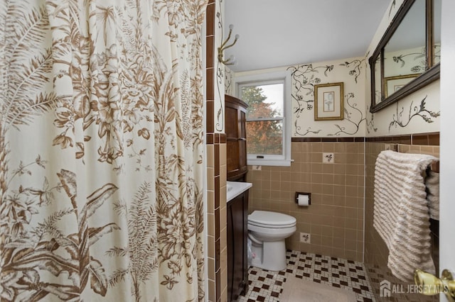 bathroom featuring toilet, vanity, tile walls, and a shower with curtain