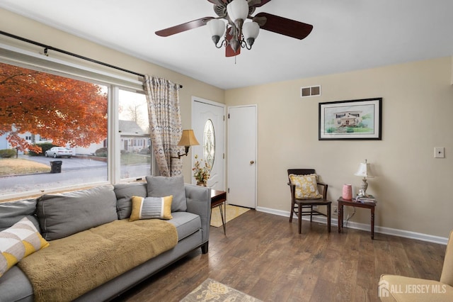 living room with dark hardwood / wood-style flooring and ceiling fan