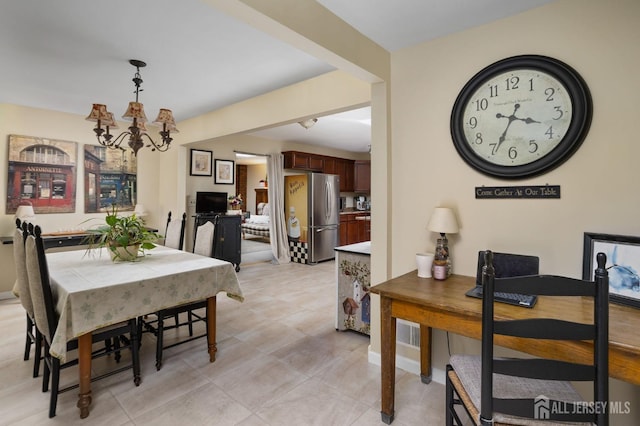 tiled dining space with a notable chandelier