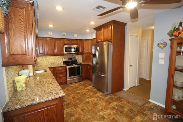 816-C Deal Rd, Monroe, NJ 08831 - kitchen with appliances with stainless steel finishes, a ceiling fan, light stone countertops, tasteful backsplash, and brown cabinetry