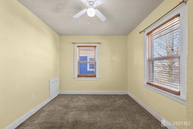 unfurnished room with carpet flooring, a ceiling fan, baseboards, and a textured ceiling