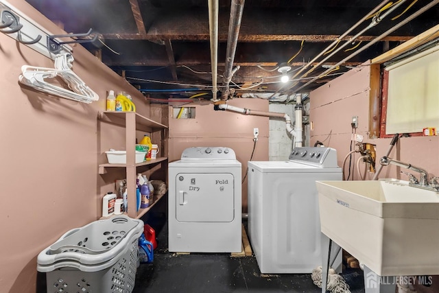 washroom with laundry area, a sink, and separate washer and dryer