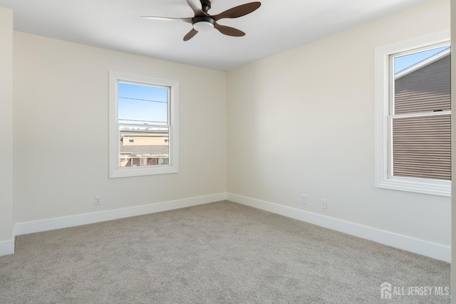 carpeted spare room with ceiling fan