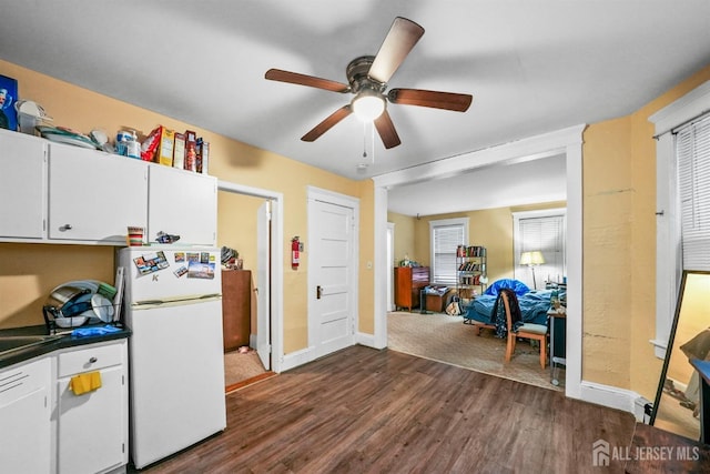 311 Magnolia St, Highland Park, NJ 08904 - kitchen with ceiling fan, dark countertops, freestanding refrigerator, white cabinetry, and dark wood-type flooring