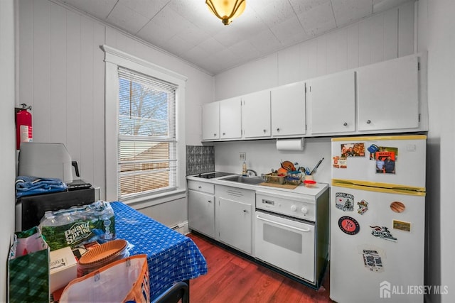 311 Magnolia St, Highland Park, NJ 08904 - kitchen featuring white appliances, dark wood-style floors, light countertops, white cabinets, and a sink