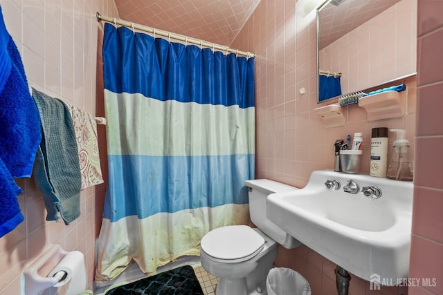 311 Magnolia St, Highland Park, NJ 08904 - full bathroom featuring curtained shower, a sink, toilet, tile walls, and tile patterned floors