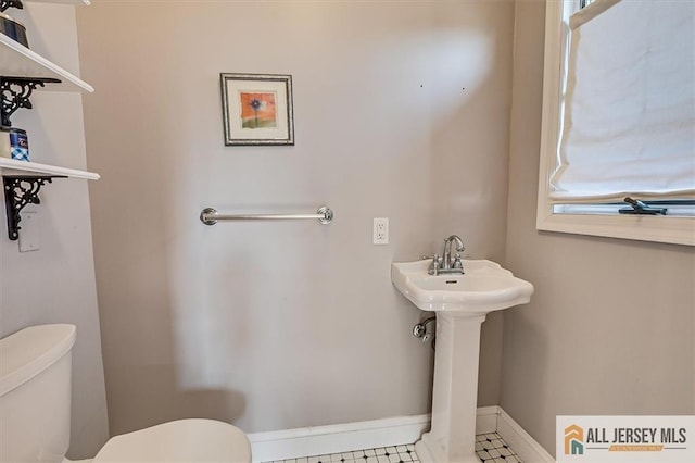 bathroom with toilet and baseboards