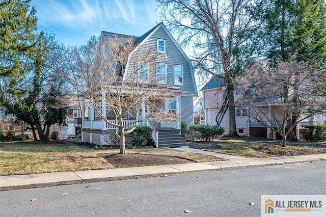 view of front of property featuring stairs, a gambrel roof, covered porch, and a front lawn