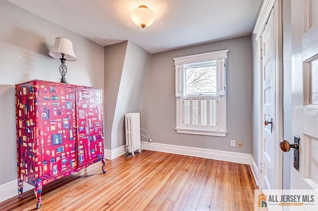 interior space with hardwood / wood-style floors, radiator, and baseboards