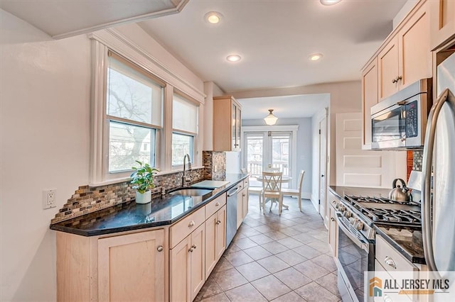 kitchen with a sink, backsplash, recessed lighting, stainless steel appliances, and light tile patterned flooring