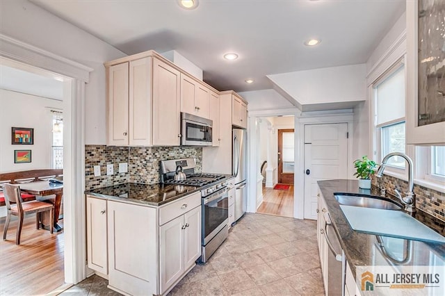 kitchen with dark stone countertops, stainless steel appliances, and decorative backsplash