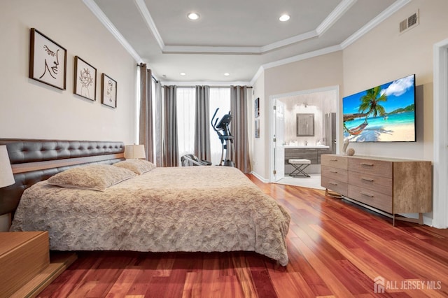 bedroom with ornamental molding, visible vents, a raised ceiling, wood finished floors, and recessed lighting