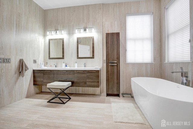 bathroom with double vanity and a soaking tub