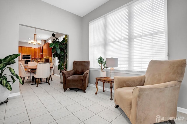 sitting room with a notable chandelier, baseboards, and light tile patterned flooring