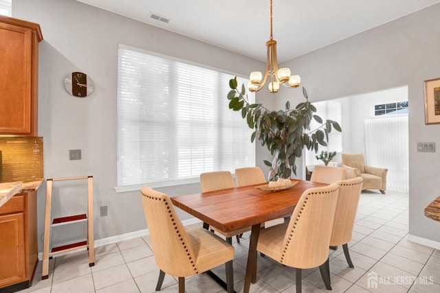 dining space with baseboards, visible vents, light tile patterned flooring, and a notable chandelier