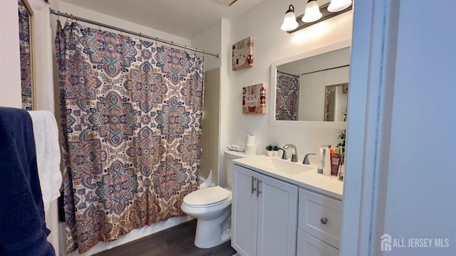 bathroom featuring vanity, toilet, wood finished floors, and shower / bath combo