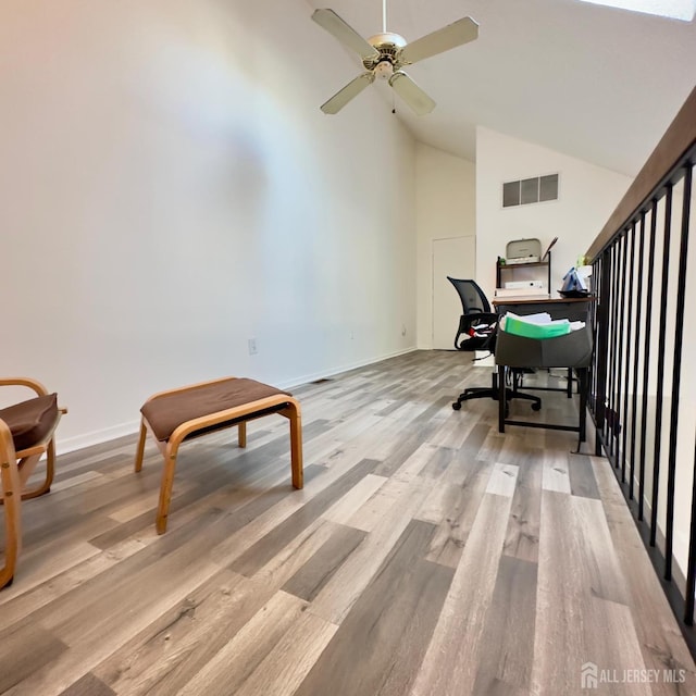 office area featuring visible vents, baseboards, ceiling fan, light wood-type flooring, and high vaulted ceiling