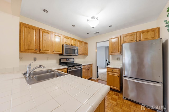 9 Lamberson Ct, Sayreville, NJ 08872 - kitchen featuring stainless steel appliances, tile countertops, a peninsula, brown cabinets, and recessed lighting