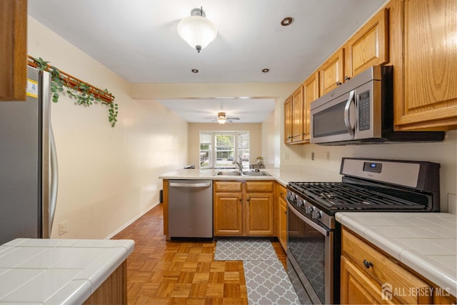 9 Lamberson Ct, Sayreville, NJ 08872 - kitchen with appliances with stainless steel finishes, tile countertops, a peninsula, and a ceiling fan