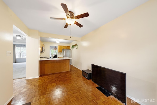 9 Lamberson Ct, Sayreville, NJ 08872 - kitchen with appliances with stainless steel finishes, a peninsula, a ceiling fan, light countertops, and brown cabinets