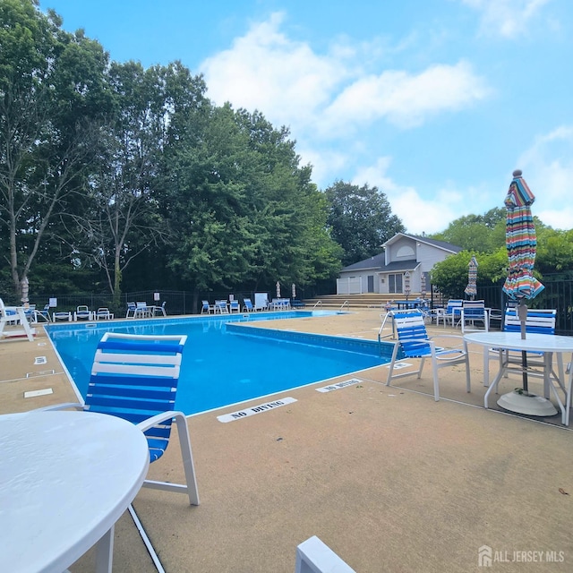 9 Lamberson Ct, Sayreville, NJ 08872 - community pool featuring a patio area and view of wooded area