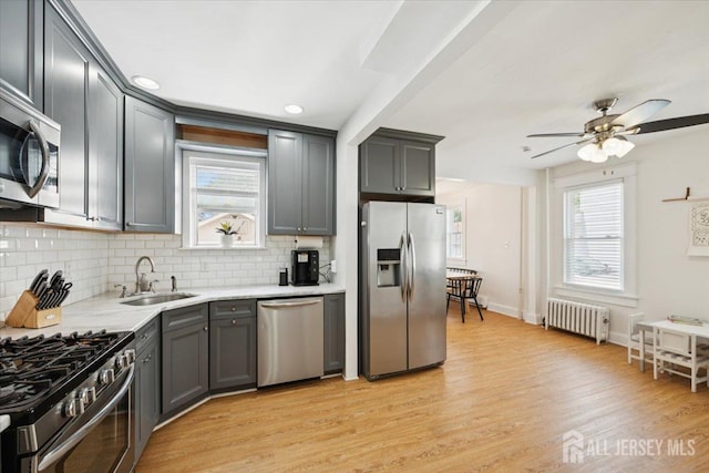 60 S St S, Milltown, NJ 08850 - kitchen featuring appliances with stainless steel finishes, radiator heating unit, tasteful backsplash, light countertops, and a ceiling fan