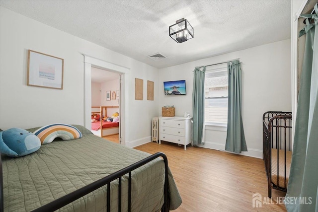 60 S St S, Milltown, NJ 08850 - bedroom featuring light wood-type flooring, a textured ceiling, and radiator heating unit