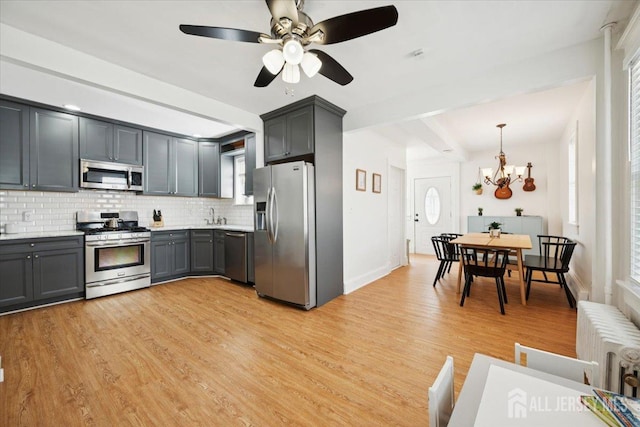 60 S St S, Milltown, NJ 08850 - kitchen featuring appliances with stainless steel finishes, radiator, tasteful backsplash, light wood-style flooring, and light countertops