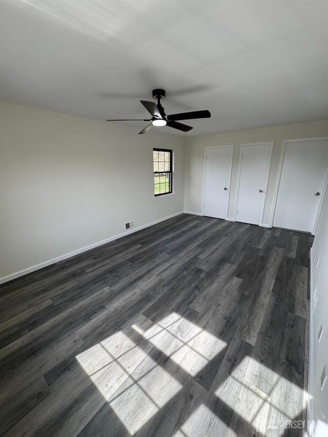 89 Golden Sq, Woodbridge Proper, NJ 07095 - unfurnished bedroom with dark wood-type flooring, a ceiling fan, and two closets