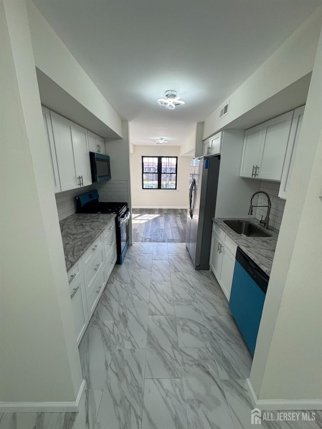 89 Golden Sq, Woodbridge Proper, NJ 07095 - kitchen with black appliances, light marble finish flooring, white cabinetry, and backsplash
