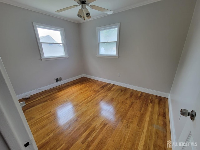 empty room with ceiling fan, ornamental molding, and light wood-type flooring