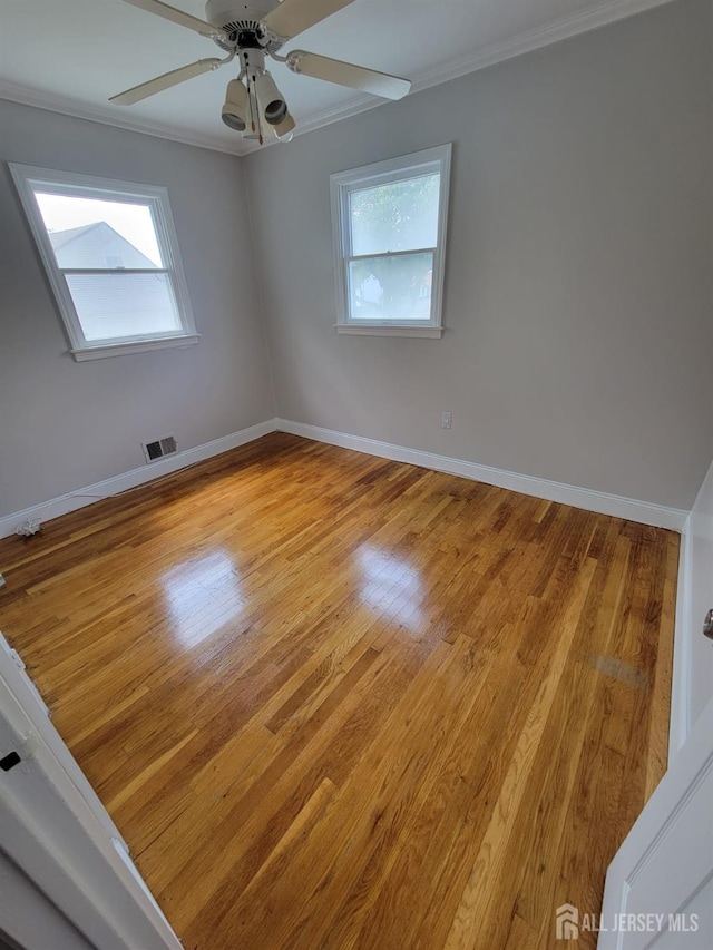 unfurnished room with crown molding, light hardwood / wood-style floors, and ceiling fan