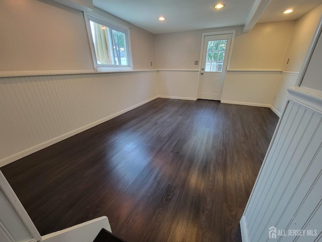 spare room with plenty of natural light and dark hardwood / wood-style flooring