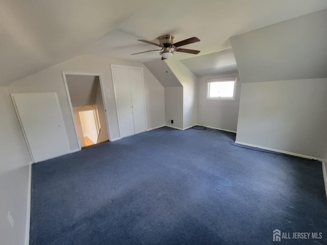 bonus room with dark colored carpet, vaulted ceiling, and ceiling fan