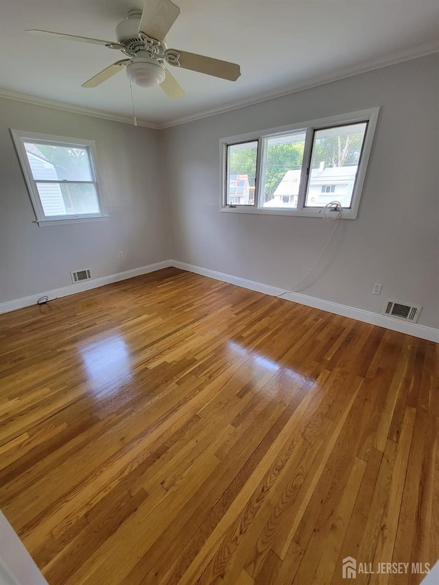 empty room featuring ornamental molding, ceiling fan, and light hardwood / wood-style flooring