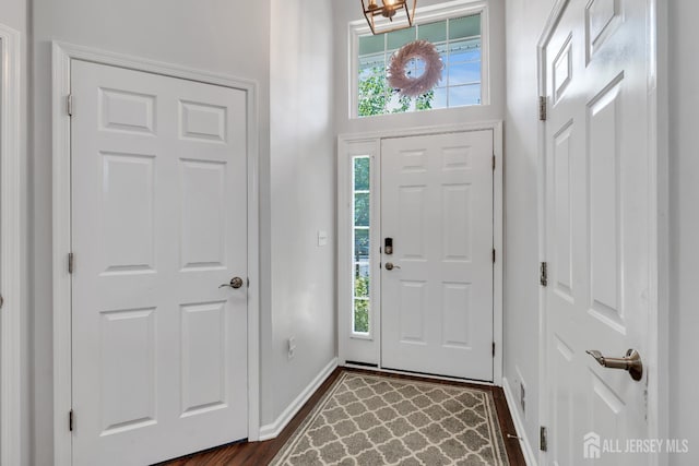 43 Capica Ct, South Amboy, NJ 08879 - entrance foyer featuring healthy amount of natural light, dark wood-style floors, and a chandelier