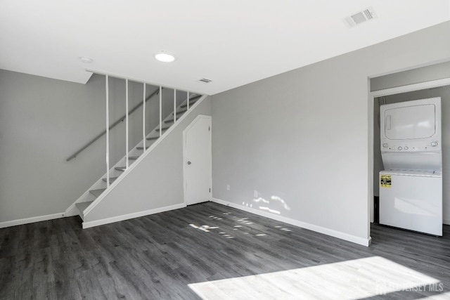 unfurnished living room featuring visible vents, baseboards, stacked washer and dryer, and stairs