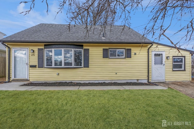 view of front of property featuring a front lawn and a shingled roof