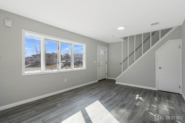 entryway with visible vents, baseboards, wood finished floors, and stairway