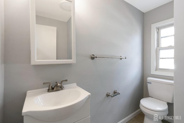 bathroom featuring vanity, toilet, and baseboards