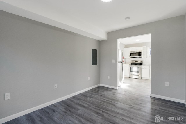 unfurnished room with electric panel, baseboards, and dark wood-style flooring