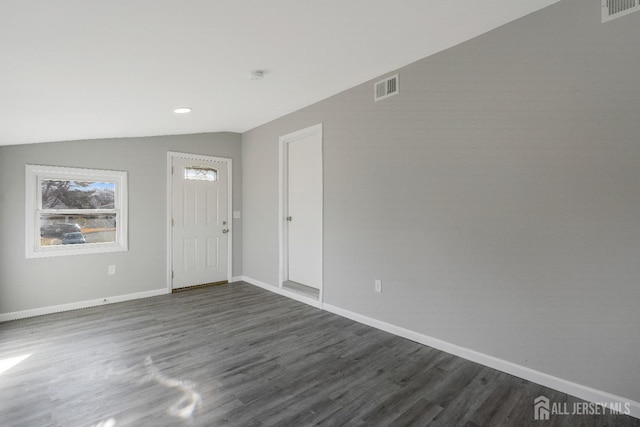 foyer featuring visible vents, lofted ceiling, baseboards, and dark wood-style flooring