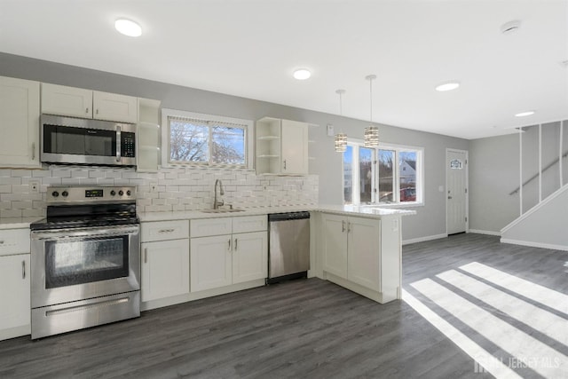 kitchen with open shelves, stainless steel appliances, light countertops, and a sink