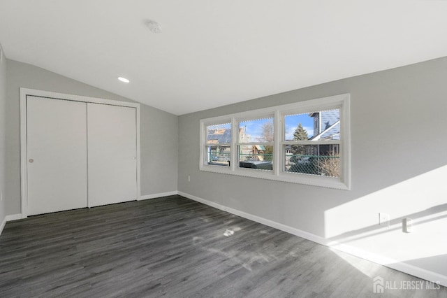 unfurnished bedroom featuring dark wood-type flooring, recessed lighting, a closet, baseboards, and vaulted ceiling